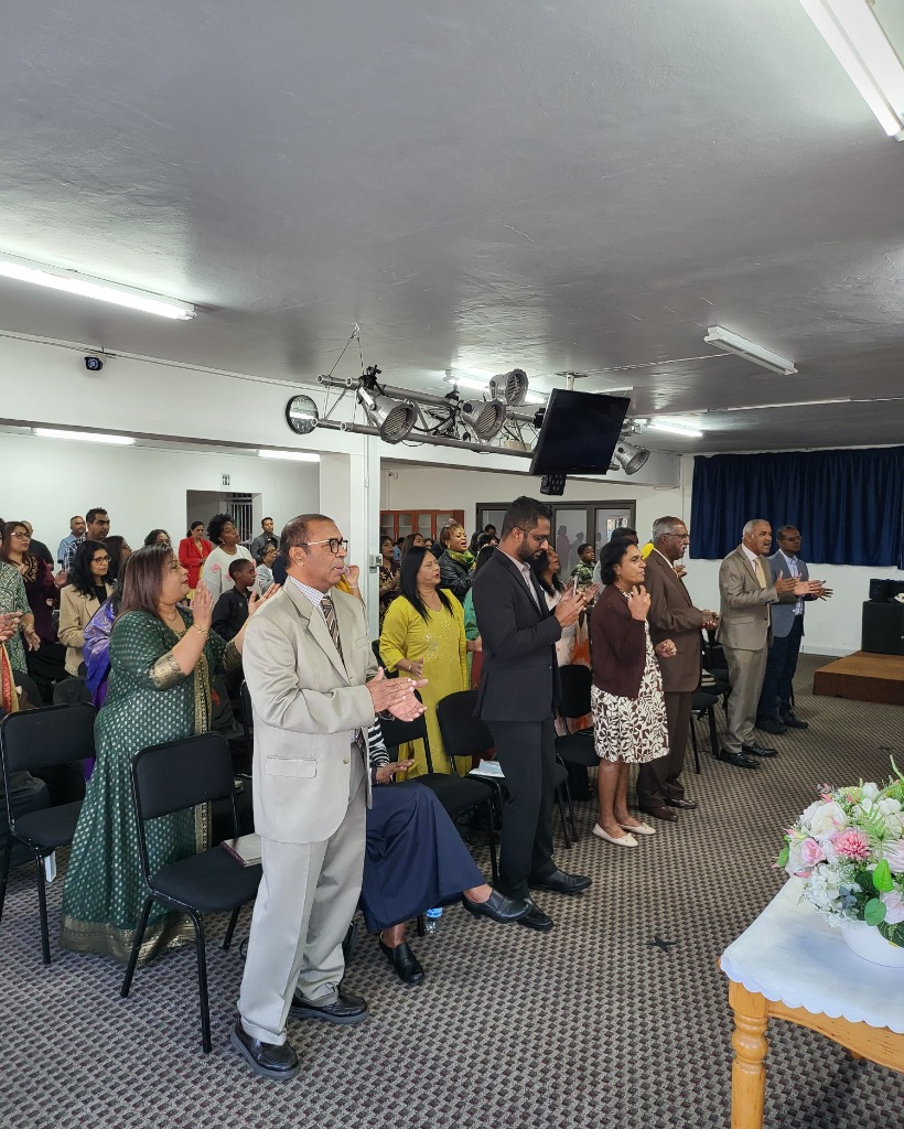 Congregation standing in worship during a Rooted service